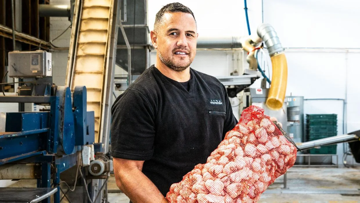 Longridge team member holding fresh garlic in processing facility